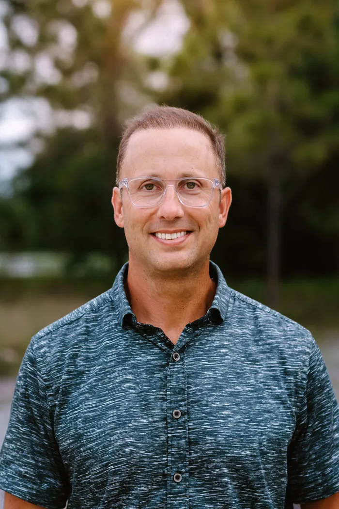 Michael Bonifacio, Co-Founder and Head of School, smiling outdoors